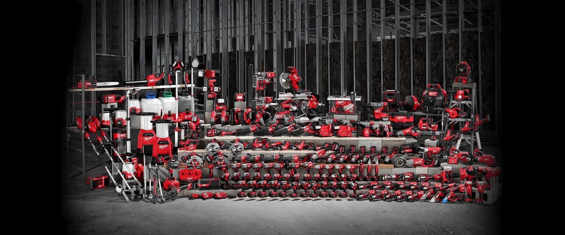 Wide selection of Milwaukee power tools and accessories on display at a construction site, representing the full range available at Spearfish Building Supply, including cordless drills, saws, impact drivers, and battery systems.